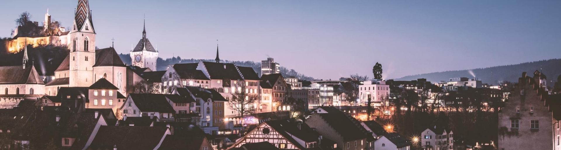 Apartment Hotel in Zürich mit Blick auf die beleuchtete Stadt am Abend 